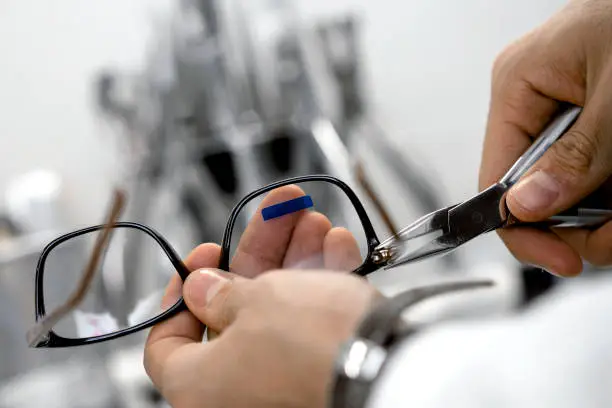 Optician repairing and fixing eye glasses