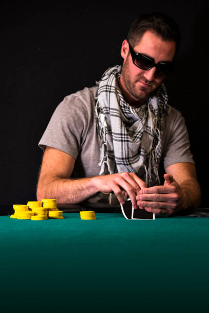 istock Male Poker Player Looking at his Cards 889771448