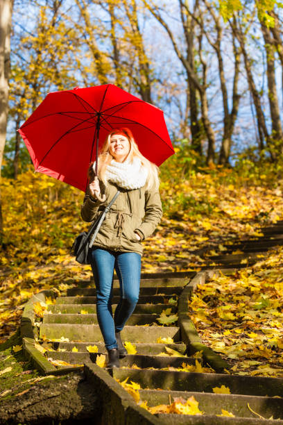 istock Woman walking in park with umbrella 889786104