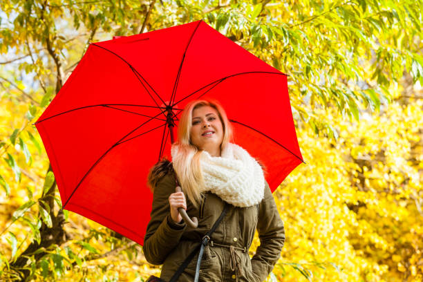 istock Woman walking in park with umbrella 889786530
