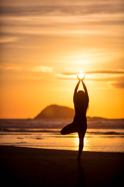kobieta robi medytację o zachodzie słońca - murawai beach zdjęcia i obrazy z banku zdjęć