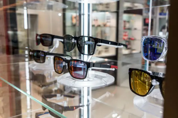 Photo of Various of sun glasses in the shop display shelves. Selective focus