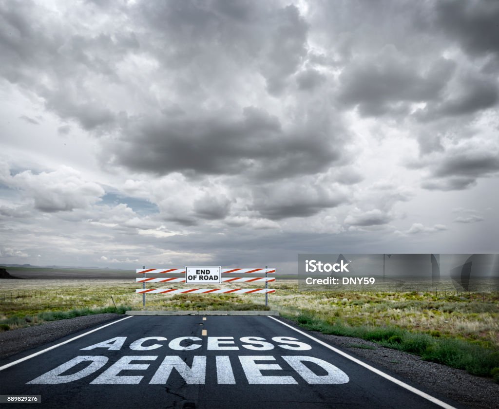 Access Denied Access denied is painted on a long rural road that comes to an abrupt end. A construction barrier serves notice the one has come to the end of the road. Road Closed Sign Stock Photo