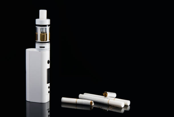 istock a broken cigarette on a black background, and a modern electronic cigarette on a black background, with a hatching 889836372