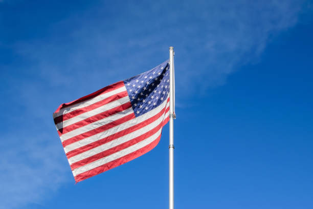 istock USA flag with blue sky 889866294