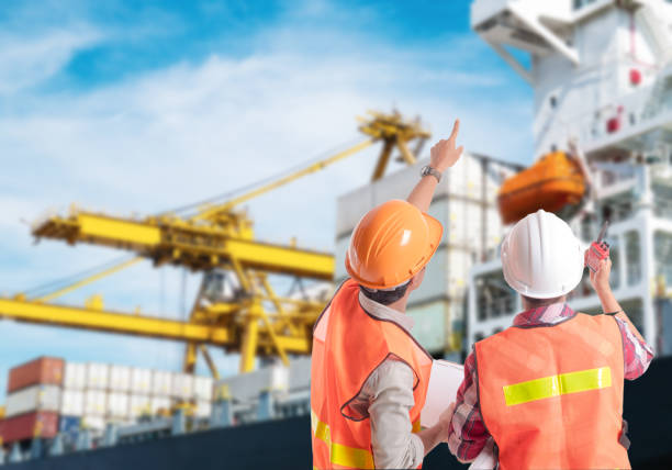 Dock worker pointing finger on control of container loading in an industrial harbor