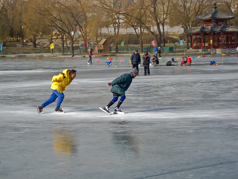 Beijing, China - January 2, 2011: Two Chinese men skating at a park of Beijing