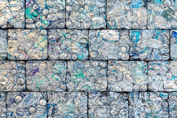 A wall of crushed aluminum cans recycled into building blocks stock photo