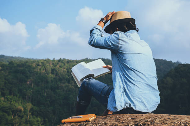 アジア人旅行は休日でリラックスします。席では、岩の崖に本を読むおくつろぎください。山。タイで - writing diary nature ideas ストックフォトと画像