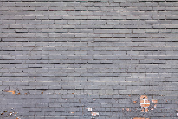 istock A gray painted brick wall with paint peeling exposing the bricks 889905824