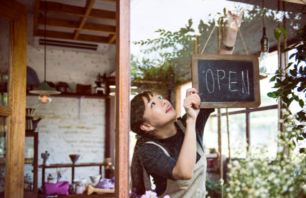 Woman hanging an open sign Woman hanging an open sign charming stock pictures, royalty-free photos & images