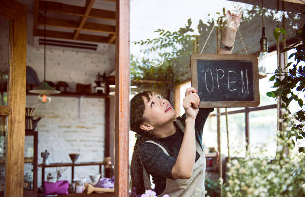 Woman hanging an open sign Woman hanging an open sign Charming stock pictures, royalty-free photos & images