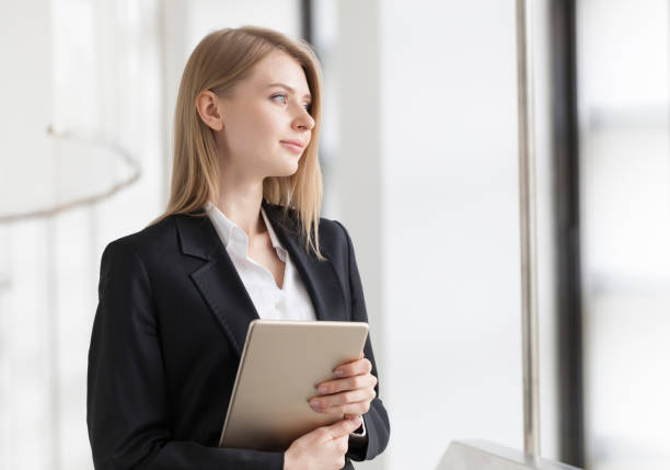 istock Cheerful young businesswoman standing with digital tablet 889935892