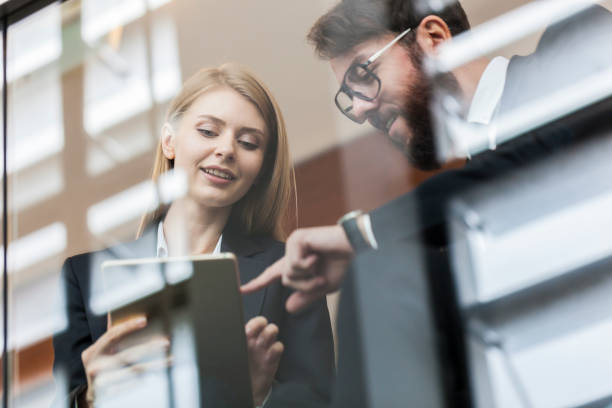 istock Two business people discussing behind the  window glass 889938316