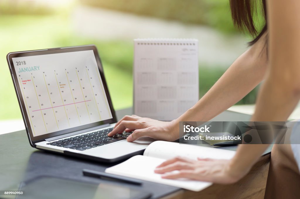 Femme à la planification de l’ordre du jour et calendrier à l’aide du planificateur d’événements de calendrier. Mains de femme à l’aide de plan pour les vacances sur ordinateur portable. Calendrier planificateur organisation gestion rappeler concept. - Photo de Calendrier libre de droits