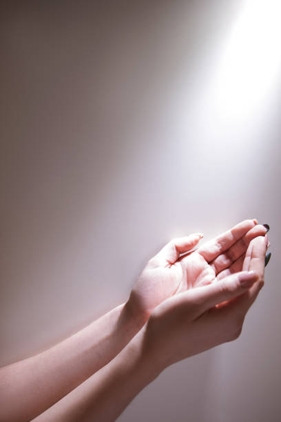 istock hands glowing light god grace fervent prayer 889946614
