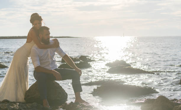 istock Young married couple on the beach by sunset. 889951598