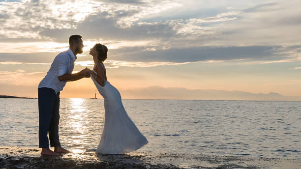 istock Young married couple on the beach by sunset. 889958664