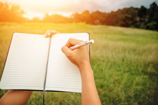 istock Handwriting on notebook relax in the holiday. on a green pasture. 889981090