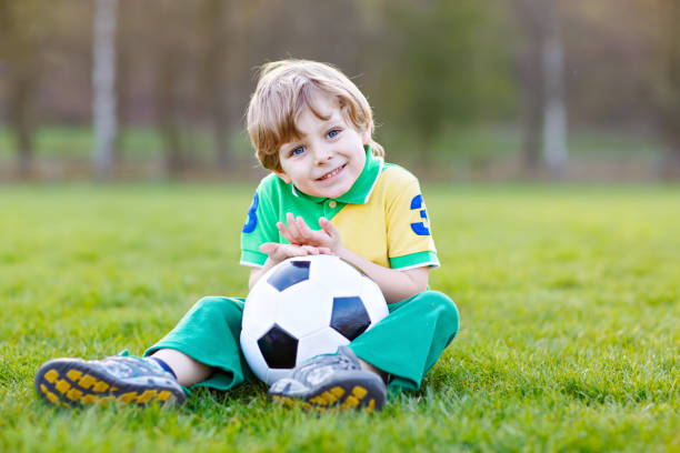 kleine süße kind junge von 4 spielen fußball mit fußball auf feld, im freien - playing field goalie soccer player little boys stock-fotos und bilder