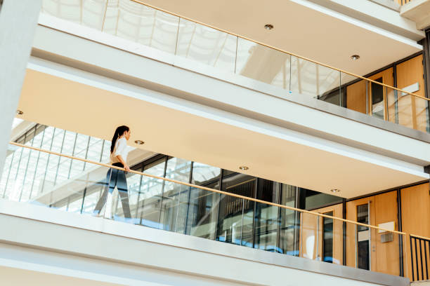 istock Elegant businesswoman walking inside building 889983792