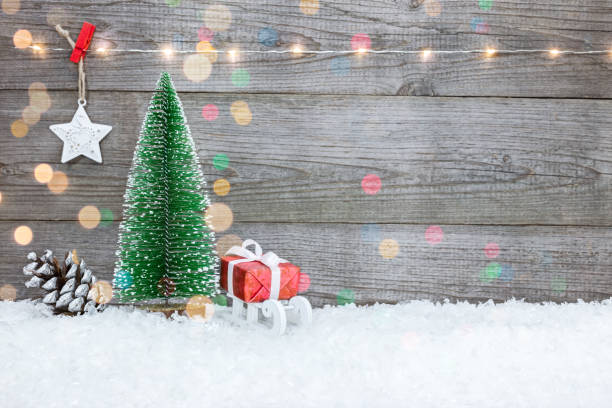 istock christmas background with gift box, holiday lights and small fir tree 889994436