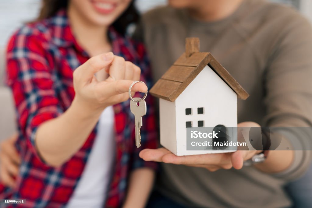 Stolz auf junge asiatische paar mit Schlüsseln und Holzhaus Modellierung - Lizenzfrei Wohnhaus Stock-Foto