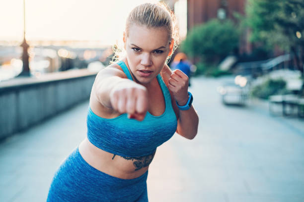 Boxing work-out Young sportswoman warming-up with boxing outdoors in the city women boxing sport exercising stock pictures, royalty-free photos & images