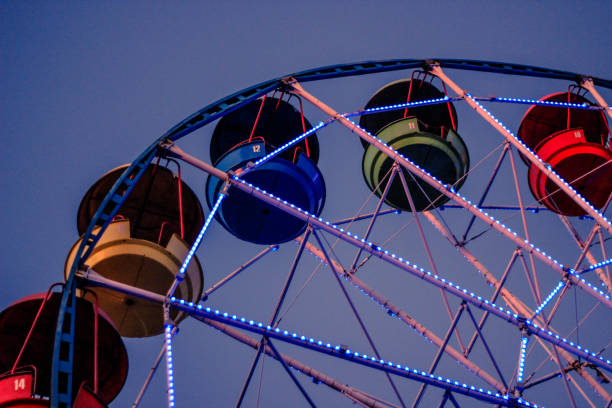 roda gigante com cabines de cor contra o céu azul - ferris wheel wheel blurred motion amusement park - fotografias e filmes do acervo