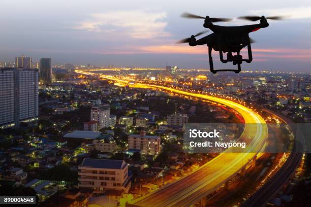 Silhouette Of Drone Flying Above City At Sunset Stock Photo - Download Image Now - Drone, City, Flying
