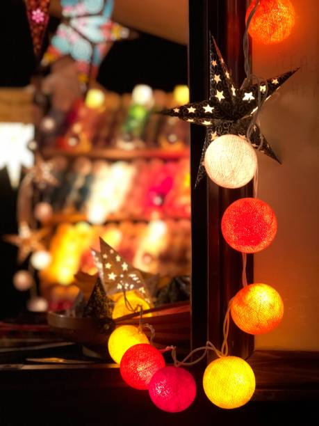 Illuminated lights and star lanterns displayed on a Christmas market stall