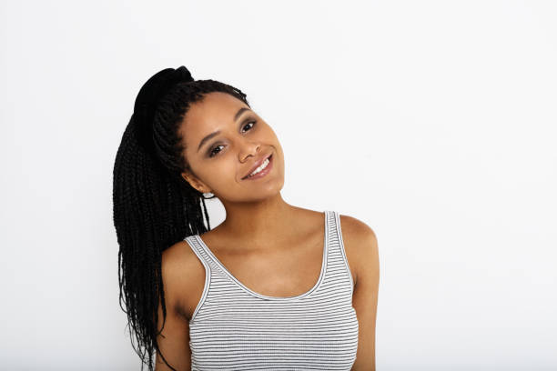 istock Smiling woman wearing white top loking at a camera with her head tilted 890052066