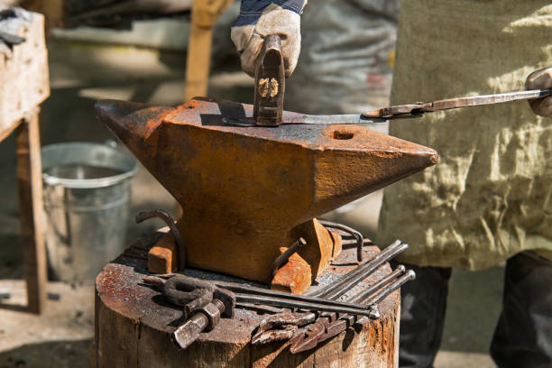 istock smith forges an iron piece on an anvil with a hammer 890056986