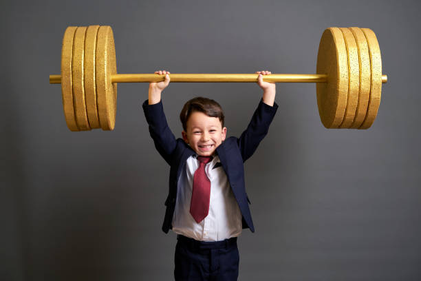 istock Cute business boy lifting gold barbell 890072764