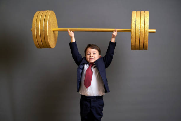 istock Cute business boy lifting gold barbell 890073286