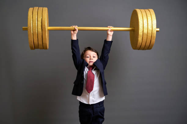 istock Cute business boy lifting gold barbell 890075506