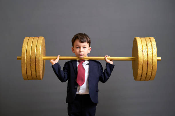 istock Cute business boy lifting gold barbell 890077596