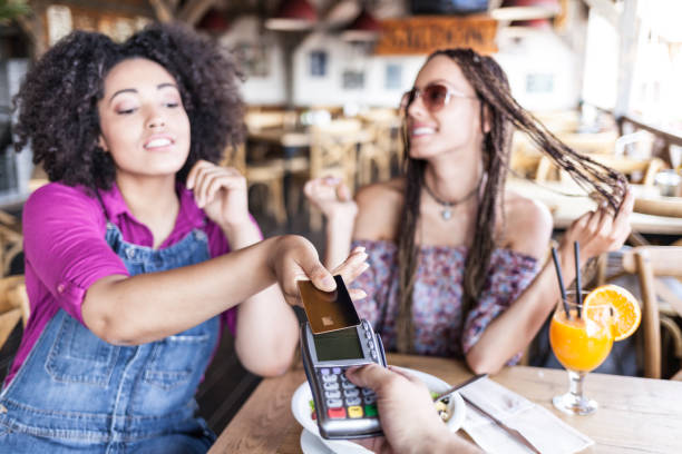 istock Cheerful friends using credit card in cafe 890080810