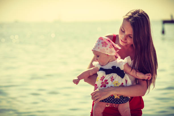 istock Mother playing with baby on beach 890080926