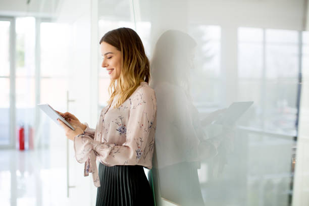 istock Young businesswoman with tablet in office 890081332