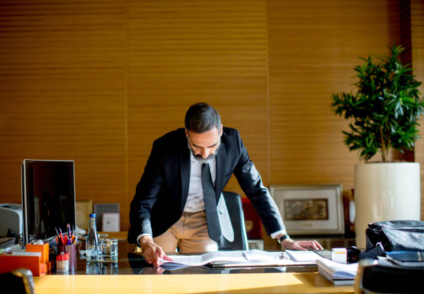 istock Handsome middle-aged businessman in modern office 890083530
