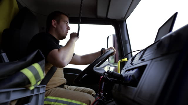 Firefighter driving a fire engine to the scene and communicating over the CB radio