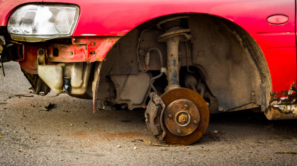 istock Car without wheels costs on brick, old rusty car brakes in poor condition. 890096510
