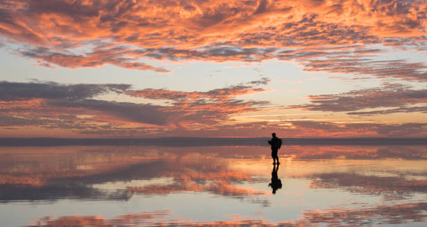 istock Photographer  having fun with Drone on salt lake at sunset 890100944