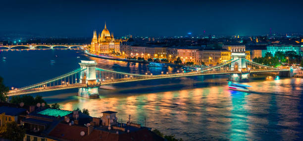 Night view of Parliament and Chain Bridge in Pest city Night view of Parliament and Chain Bridge in Pest city. Colorful evening cityscape of Budapest, Hungary, Europe. Artistic style post processed photo. budapest danube river cruise hungary stock pictures, royalty-free photos & images
