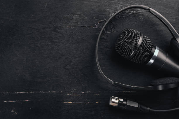 istock Headphones and microphone on a wooden black table. Studio. Top view. Free space for text. Copy space. 890110078