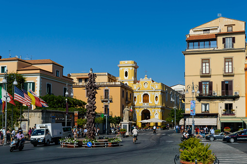 The beautiful town of Sorrento and its main square. People are walking along the road and visiting the city.