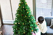 クリスマス ツリーを飾る日本女性