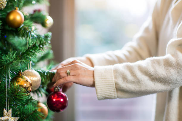 istock Female hands hanging a decoration on a Christmas tree 890115380