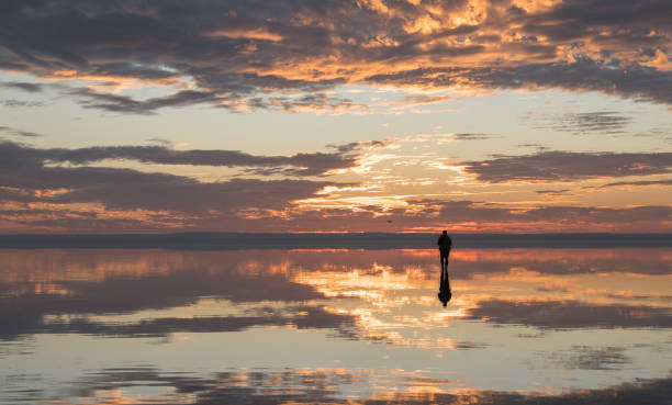istock Photographer  having fun with Drone on salt lake at sunset 890115560